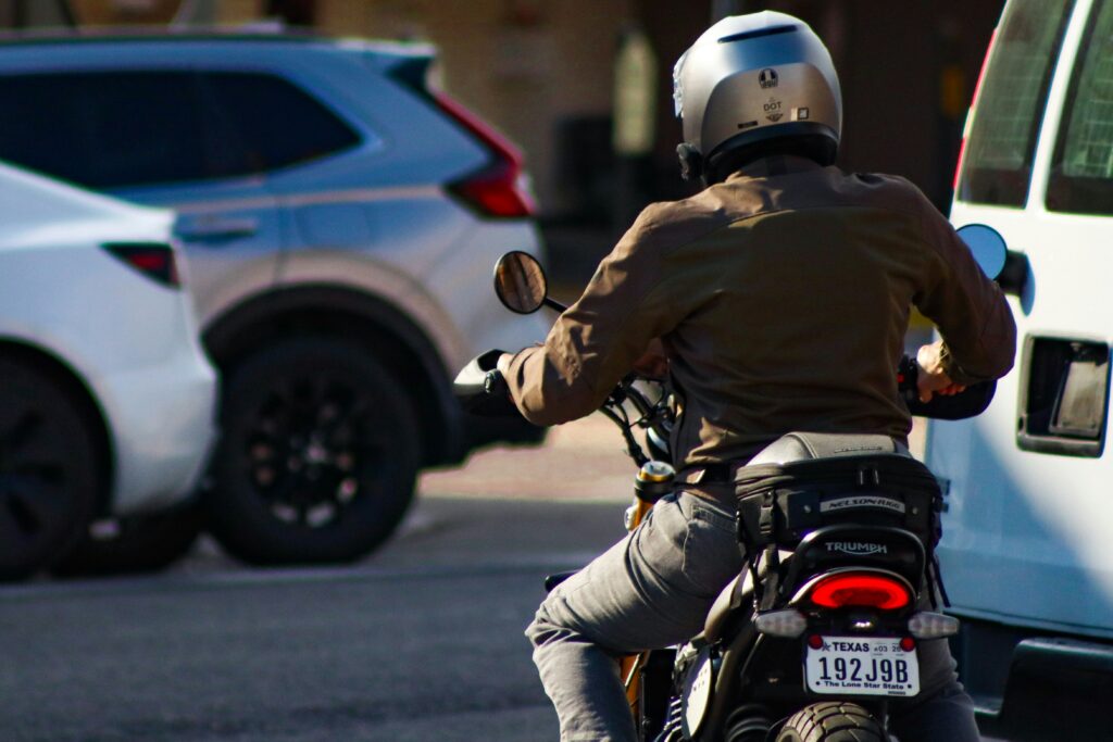 Motorcyclist riding between cars in urban traffic — San Francisco motorcycle accident lawyer John J. Roach