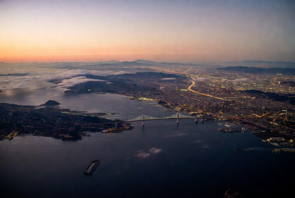 Aerial Bay Area twilight view — personal injury attorney John J. Roach serves clients across San Francisco, Oakland, Berkeley, San Jose, Daly City, and the entire Bay Area