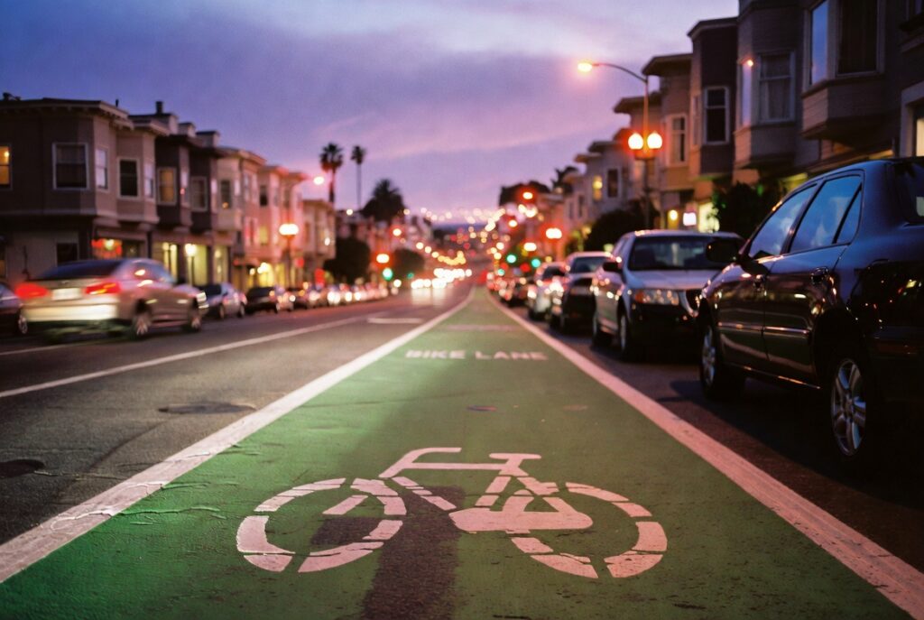Carril de bicicleta en una calle del Mission District de San Francisco al atardecer — uno de los corredores donde repartidores hispanos de comida enfrentan riesgo diario de accidentes con vehículos motorizados