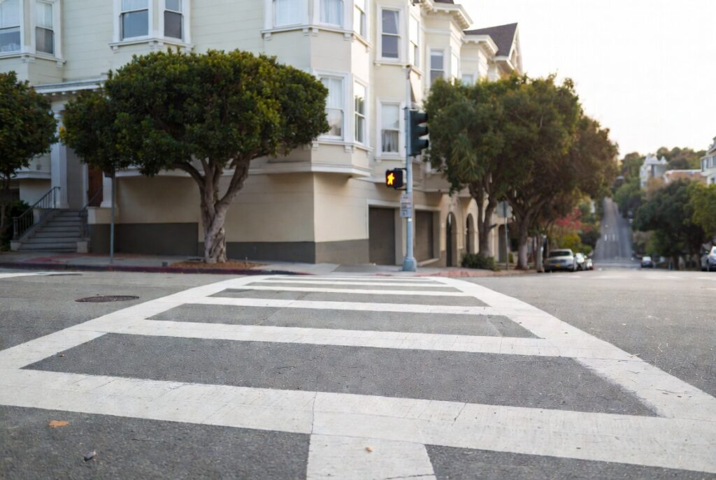 Marked crosswalk at a Pacific Heights residential intersection where California Vehicle Code § 21950 requires drivers to yield to pedestrians