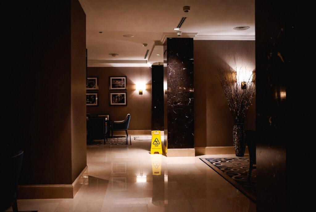 Polished hotel lobby floor and wet-floor hazard where slip and falls occur