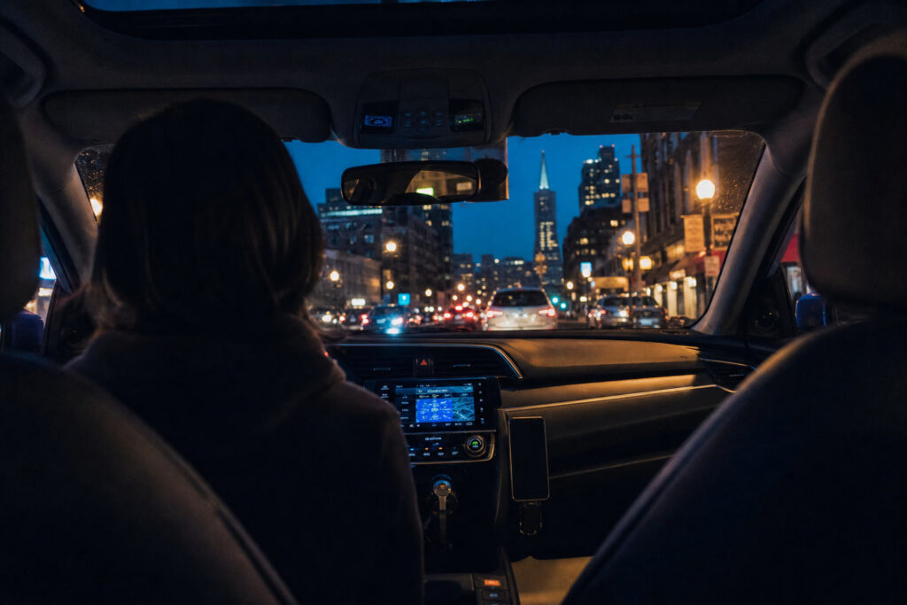 Passenger view from a San Francisco rideshare at dusk with Transamerica Pyramid ahead — coverage periods determine available insurance