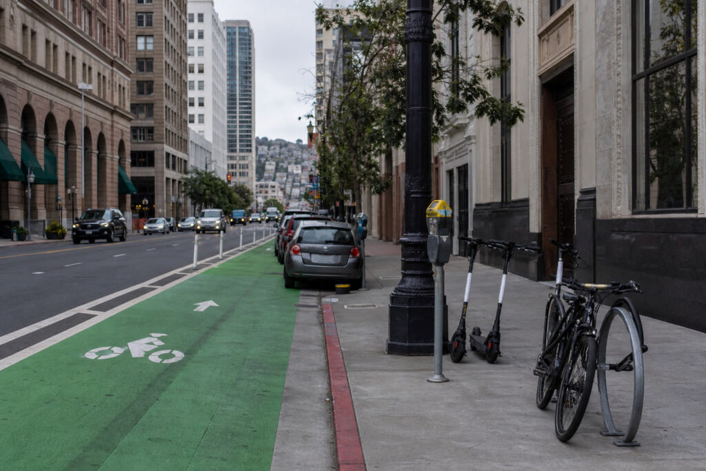 Shared e-scooters and bicycles beside a San Francisco protected bike lane