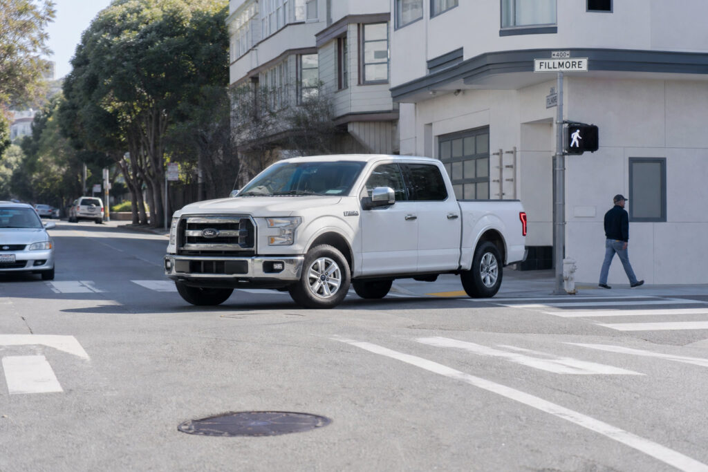 Camioneta Ford F-150 blanca girando a la izquierda cerca de un cruce peatonal marcado en San Francisco