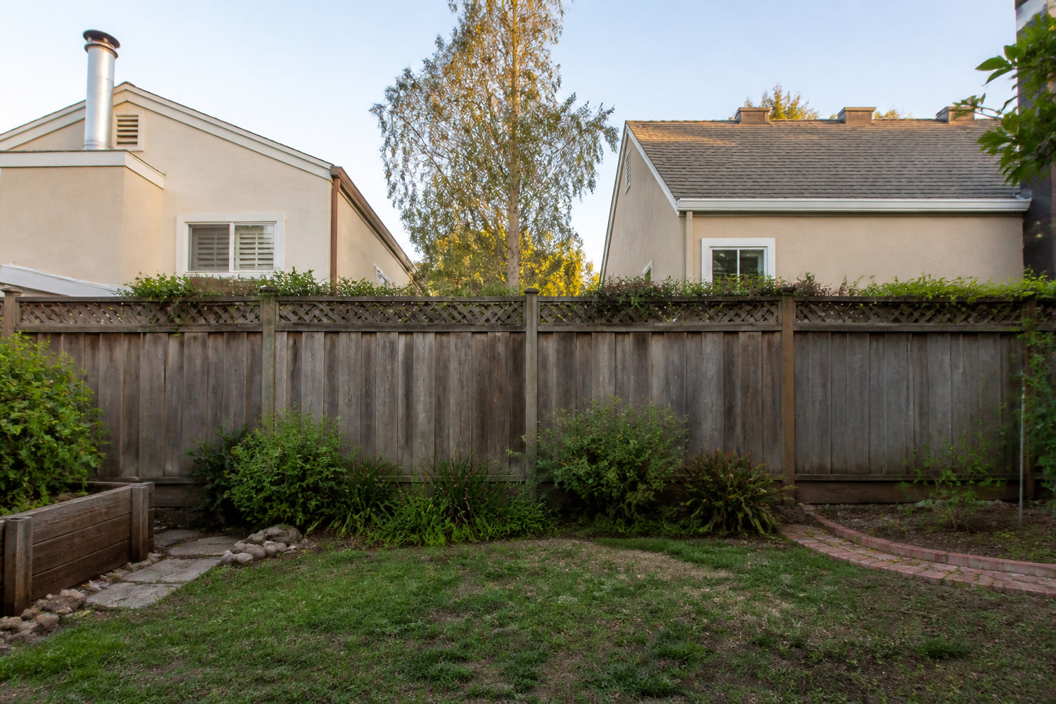 Shared wooden backyard fence between two East Bay houses